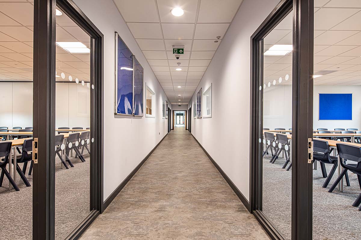 Modern school corridor with glass walls into classrooms